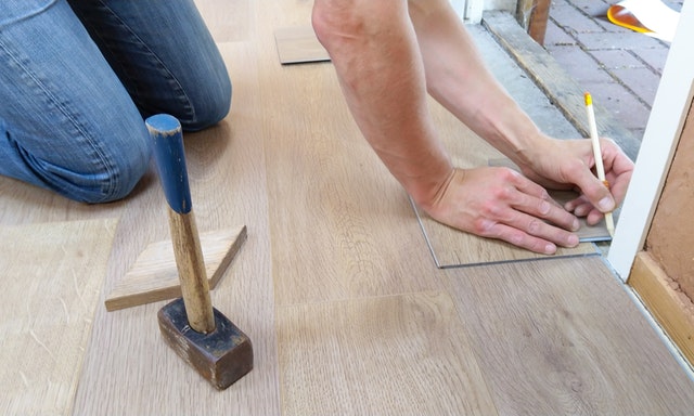 contractor noting the length of flooring to fit it in a corner
